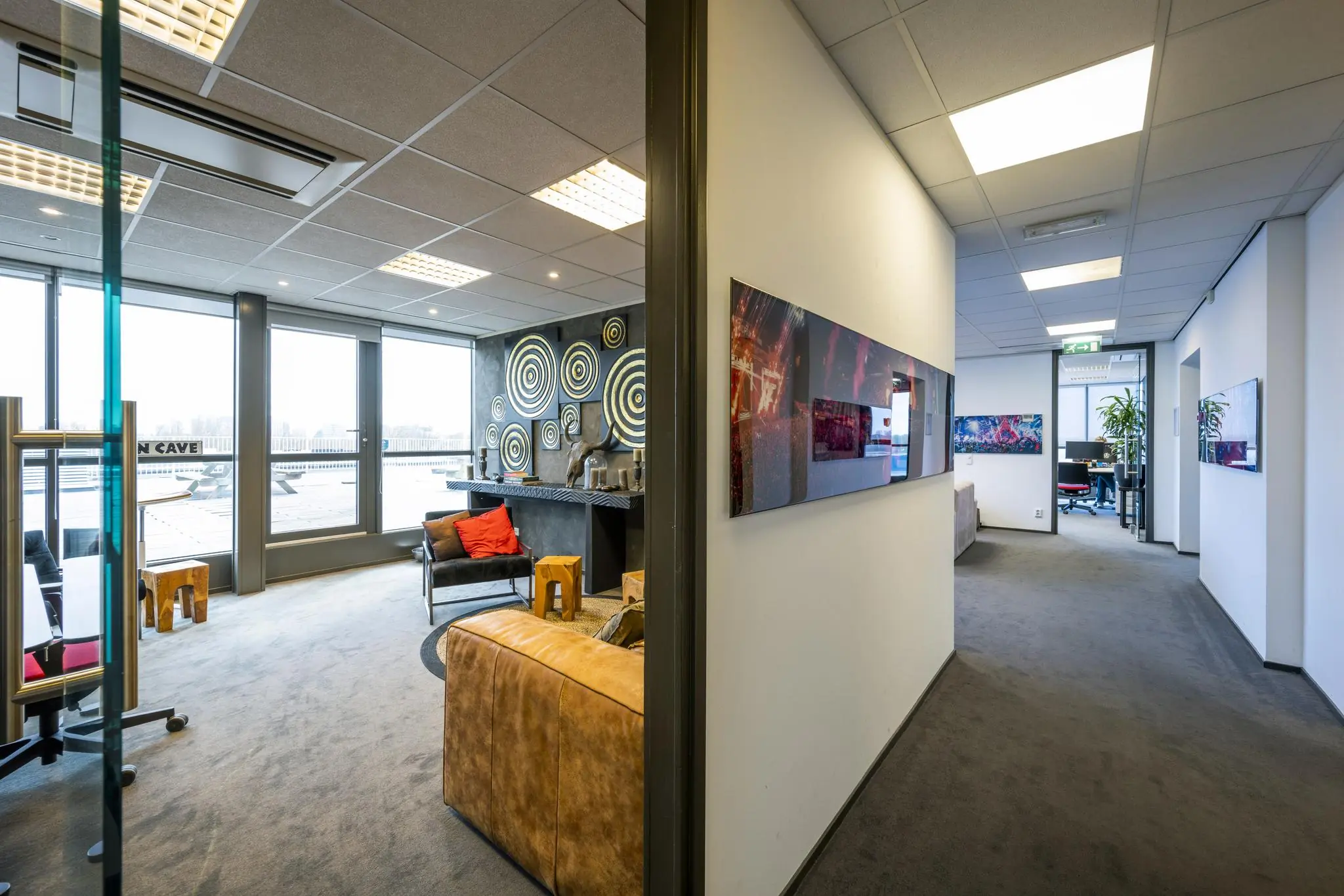 Moderne kantoorruimte aan de Anthony Fokkerweg met loungehoek, wanddecoratie en zicht op werkplekken.